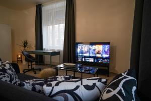 sala de estar con sofá y TV de pantalla plana en Lucy's Apartments, en Olomouc