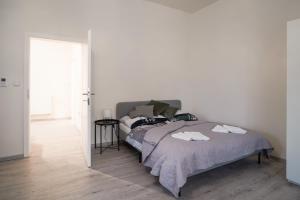 Un dormitorio blanco con una cama con toallas. en Lucy's Apartments, en Olomouc