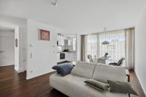 a living room with a couch and a kitchen at Luxus 3-Zimmer Apartment mit Balkon & Homeoffice & Parkplatz in TOP-Lage nahe an Mercedes-Benz mit Kinderbetten in Böblingen