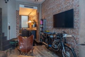 a motorcycle parked next to a brick wall with a television at Superbe Hammam à Paris Montparnasse in Paris