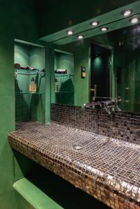 ein Badezimmer mit einem großen Spiegel und einem Waschbecken in der Unterkunft Superbe Hammam à Paris Montparnasse in Paris