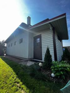 Biały dom z drzwiami i trawnikiem w obiekcie Modern DIY apartment w mieście Peetri