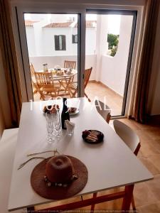 ein weißer Tisch mit einem Hut und einer Brille darauf in der Unterkunft Beach Apartment Terrace in Vilamoura