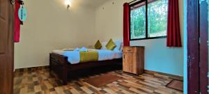 a bedroom with a bed and a window at Chalona Hill View in Munnar
