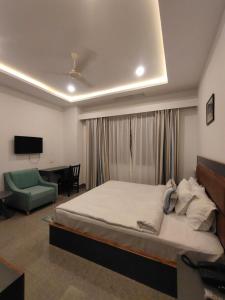 een slaapkamer met een bed, een bank en een televisie bij The Garuda Hotel And Spa in Gangtok