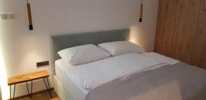 a bed with white sheets and pillows in a room at AppPrusnik in Ljubljana