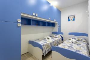 two beds in a room with blue walls at Sefy Mare A Selinunte in Marinella di Selinunte