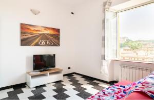 a living room with a tv and a checkered floor at casa vacanza Laura in Genova