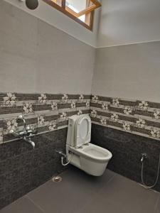 Dirang Dzong的住宿－Hotel 7 Eleven，浴室设有墙上鲜花的卫生间。