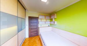 a room with a bed and a green wall at Nový apartmán v Ostravě u Mišky s akváriem a výhledem z balkonu na Beskydy in Ostrava