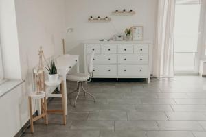 a room with a white dresser and a table and chairs at Ferienhaus Stiefel in Schutterwald