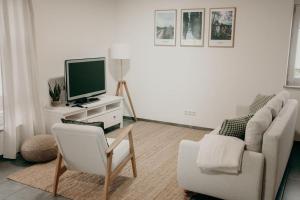 a living room with a couch and a tv at Ferienhaus Stiefel in Schutterwald