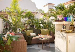 a patio with a couch and a table at LohonoStays Colina Villa A in Assagao