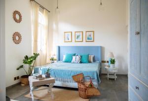 a bedroom with a blue bed and a table at LohonoStays Colina Villa A in Assagao