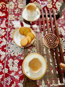 - une table avec des assiettes de pâtisseries et une tasse de café dans l'établissement White Butterfly, à Trivandrum