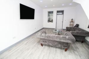a living room with two couches and a flat screen tv at Remarkable 4-Bed House in Bradford in Bradford