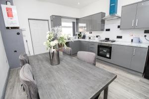 a kitchen with a wooden table with flowers on it at Remarkable 4-Bed House in Bradford in Bradford