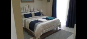 1 dormitorio con 1 cama grande con almohadas azules en Potgieter's View, en Reebok