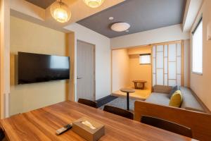 a living room with a table and a flat screen tv at stayme THE HOTEL Ueno in Tokyo
