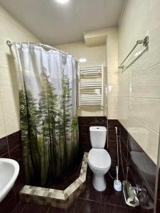 a bathroom with a toilet and a shower curtain at Hotel Marioni in Tbilisi City