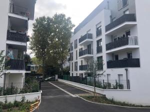 楠泰尔Jolie chambre à Nanterre Préfecture proche La Défense Aréna Campus SNCF et Paris的公寓大楼前的一个空停车位