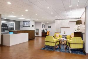 uma sala de espera com cadeiras amarelas e uma mesa em Hampton Inn Naples-Central em Naples