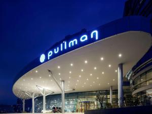 イスタンブールにあるPullman Istanbul Hotel & Convention Centerの夜間の看板のある建物