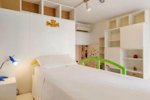 a bedroom with a white bed with a green rail at Vodice Flexyrent apartment in Milan