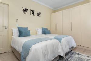 a bedroom with two beds with blue pillows at The Tram Home Stay in Franschhoek