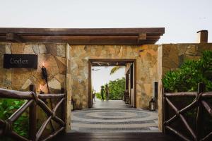 uma entrada para um resort com uma parede de pedra em Conrad Punta de Mita em Punta Mita
