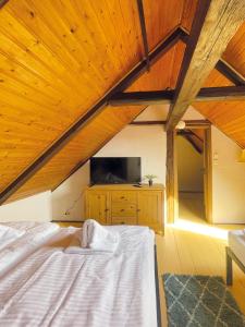 クヴェードリンブルクにあるFerienhaus Schuhhofのベッドルーム1室(ベッド1台、木製天井のテレビ付) +32枚の写真