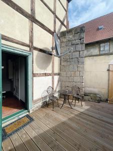 クヴェードリンブルクにあるFerienhaus Schuhhofの石壁のパティオ(椅子、テーブル付)
