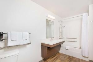 a white bathroom with a sink and a mirror at WoodSpring Suites Savannah Pooler in Savannah +24 photos