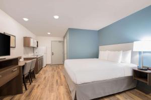 a hotel room with a large bed and a kitchen at WoodSpring Suites Savannah Pooler in Savannah