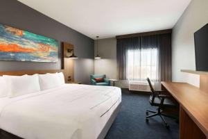 a hotel room with a large bed and a desk at La Quinta Inn & Suites by Wyndham College Station North in College Station +32 photos