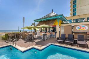 einen Pool im Gasthof mit Tischen und Stühlen und ein Restaurant in der Unterkunft Hilton Vacation Club Ocean Beach Club Virginia Beach in Virginia Beach