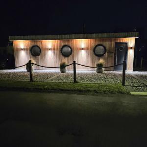a building with lights on the side of it at night at Humberston Boathouse Lodges with Hot Tub - Cleethorpes Beach Cabin Chalet in Humberston