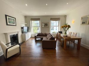 uma sala de estar com um sofá e uma mesa em Victoria Maisonette Apartment em Londres