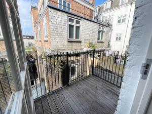 een balkon met een houten terras en een gebouw bij Victoria Maisonette Apartment in Londen