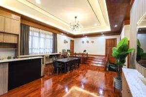 Il comprend une grande cuisine et une salle à manger avec une table et des chaises. dans l'établissement Chamber’ 64 private pool villa, à Chiang Mai