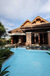 une maison avec une piscine devant une maison dans l'établissement Chamber’ 64 private pool villa, à Chiang Mai
