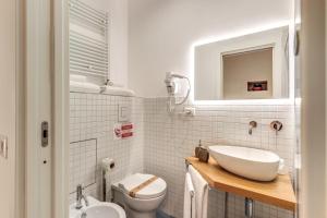 a white bathroom with a sink and a toilet at La Corte Di Partenope in Naples