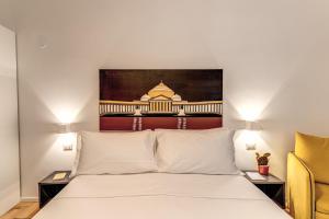 a bedroom with a white bed and a chair at La Corte Di Partenope in Naples