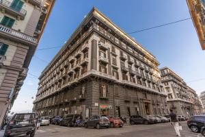 a large building on a city street with cars parked at La Corte Di Partenope Napoli in Naples