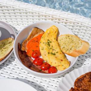 a bowl of food with eggs and tomatoes on a table at La Kana Boutique Villa in Kamphaeng Phet