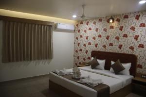 a bedroom with a bed and a floral wall at The Sky Comfort Beach Hotel, Dwarka in Dwarka