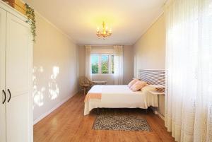 a bedroom with a bed and a window and a chandelier at Villa La Palmera in Mortera