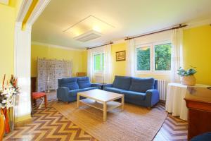 uma sala de estar com dois sofás azuis e uma mesa em Villa La Palmera em Mortera