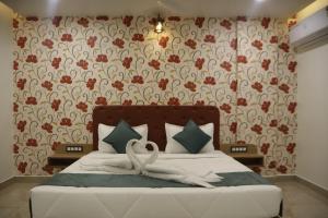 a bedroom with a bed with two swans on it at The Sky Comfort Beach Hotel, Dwarka in Dwarka
