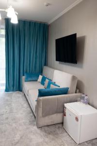 ein Wohnzimmer mit einem Sofa und einem Flachbild-TV in der Unterkunft River Stone Hotel in Scheschory